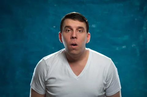 Shocked man posing on blue background Stock Photos