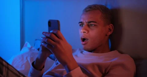 Shocked man text messaging on mobile phone in bedroom Video stock 145290319
