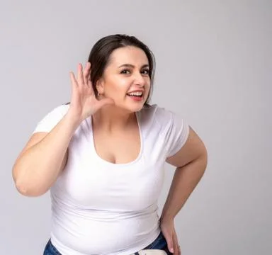 Shocked Plus Size Model with long hair posing in studio. Listen Stock Photos