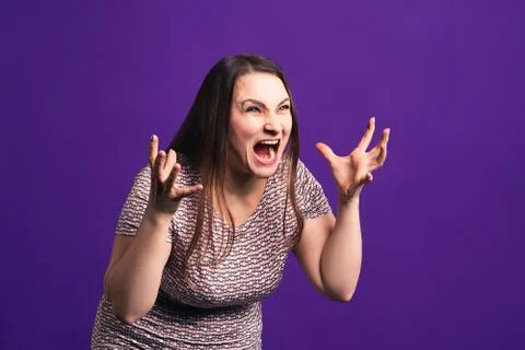 Shocked plus size model with wide open mouth on purple background Stock-Fotos