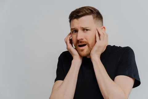 Shocked scared man looking at camera with frightened face expression Stock Photos