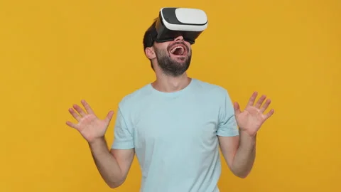 Shocked surprised young man in basic casual blue t-shirt watching in vr headset Stock Footage 148291847