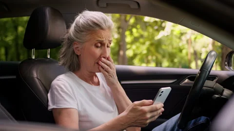 Shocked upset scared Caucasian elderly aged woman female car driver client user Stock Footage 291541763