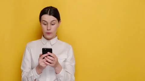 Shocked woman using mobile cell phone pointing index finger aside say wow Stock Footage 149984626