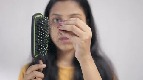 Shocked young lady taking out lost hair from the hair brush. Stock Footage 311514208
