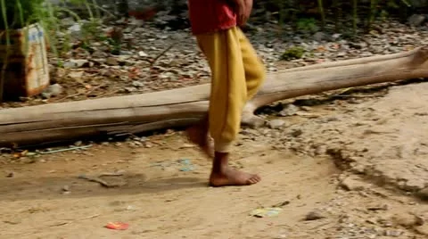 Shoe Less Boy Walking on Dirt Road Stock Footage 20059355