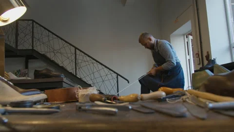 Shoe manufacturing workshop. Handmade work. Shoemaker sews shoes Video stock 137394245