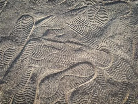 Shoe pattern on volcanic beach sand Stock Photos