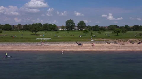 Shoebury beach drone shot featuring paddleboarders, bright sunshine, 4K UHD Video stock 169186117
