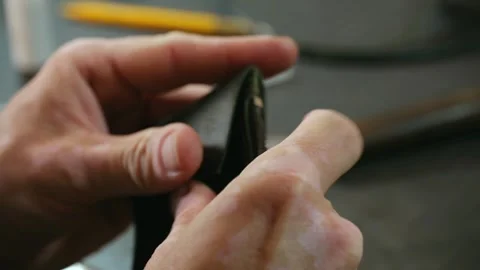 Shoemaker assembling leather wallet parts Stock Footage 296749481