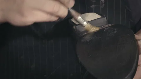 Shoemaker brushig a sole with glue Stock Footage 61790128