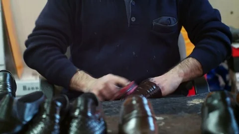 Shoemaker cleaning shoe with sponge at cobbler workshop. Close up view. Stock-Footage 71248934