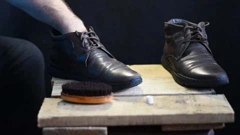 Shoemaker cleans shoes with a brush. Stock Footage 228997837