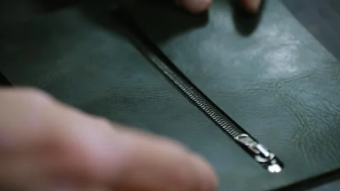 Shoemaker closing a zipper on green leather Video stock 296748941