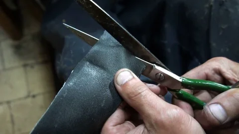 The shoemaker cuts out a patch for shoes Stock Footage 77872874