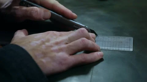 Shoemaker cutting leather with cutter and ruler Stock-Footage 296748573