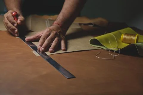 Shoemaker cutting leather with precision and steel ruler Stock Photos