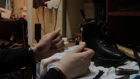 Shoemaker fixing shoe in his workshop 库存影片 130856126