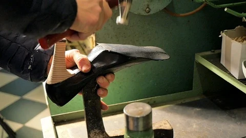 Shoemaker hammers the sole of a woman's shoe - Slow Motion Stock Footage 85525341