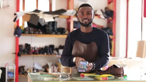 Shoemaker hand pushing the button and swipe credit card payment Stock Footage 104983360