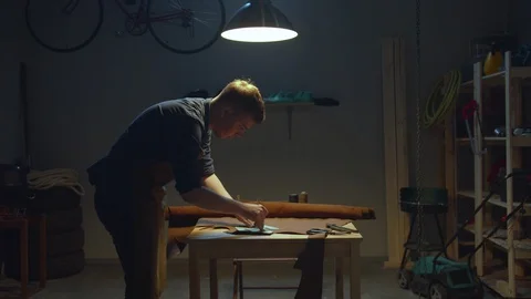 Shoemaker makes a leather pattern at home Stock Footage 127836850