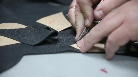 Shoemaker master cutting shoe leather as template, clicking the upper Stock Footage 82121090