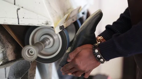 Shoemaker performs shoes in the studio craft grinder machine. Stock Footage 104984010