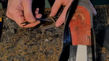 Shoemaker puts the glue on the heel of a woman's shoe Stock Footage 85525526