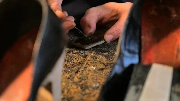 Shoemaker puts the glue on the heel of a woman's shoe Stock Footage 85525535