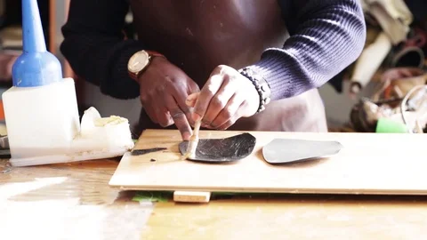 Shoemaker puts the glue on the sole of a shoe Stock Footage 104984809