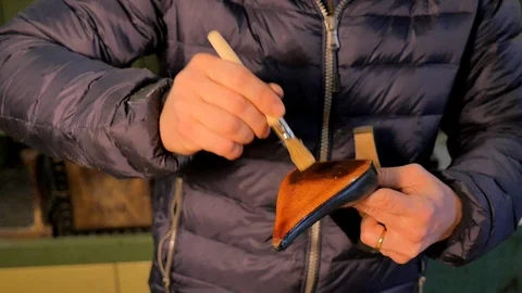 Shoemaker puts the glue on the sole of a woman's shoe Stock Footage 85525380