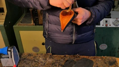 Shoemaker puts the glue on the sole of a woman's shoe Stock Footage 85525396