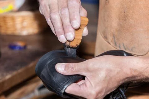 The shoemaker puts shoe polish Stock Photos