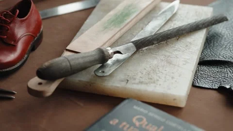 Shoemaker Rasp and Hand Tools Beside Red Leather Shoe on Workbench Stock Footage 343975306