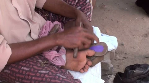 Shoemaker repairing sandals Stock Footage 67859140
