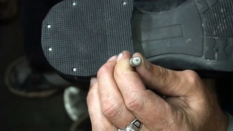 Shoemaker repairing a shoe in workshop 4k nail the heel cap to the heel Stockbeeldmateriaal 77877470