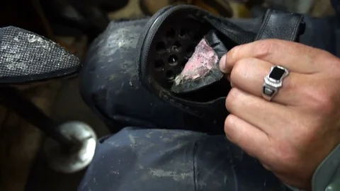 Shoemaker repairing a shoe in workshop 4k,sizing shoes Vidéo 77870055