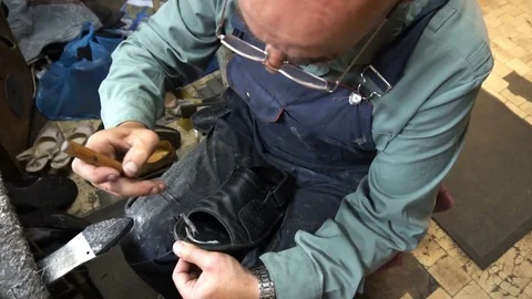 Shoemaker repairing a shoe in workshop 4k,sizing shoes Stock Footage 77870941
