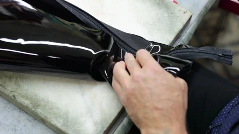 A shoemaker repairs the zipper on leather boots. Stock Footage 309805041