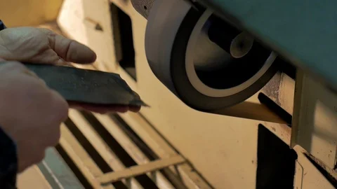 Shoemaker smooths the rubber sole of a woman's shoe Stock Footage 85525575