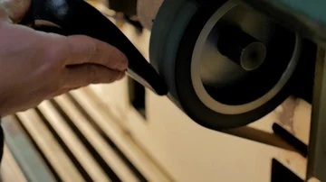 Shoemaker smooths the sole of a woman's shoe Stock Footage 85525568