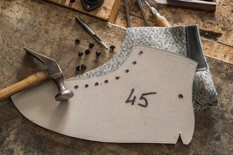 Shoemaker stencil with felt part besides hammer and Eyelet setter eyelets hook Stock Photos