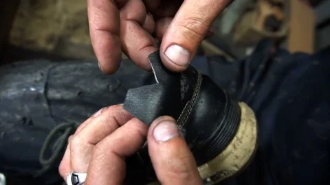 The shoemaker sticks a black leather patch on sneakers Vídeos de archivo 77879187