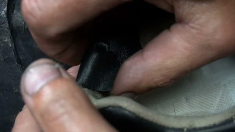 The shoemaker sticks a black leather patch on sneakers Stock Footage 77879559