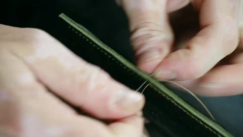 Shoemaker stitching green leather with needle and thread Stock Footage 296749777