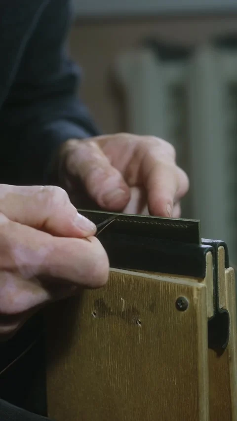 Shoemaker stitching leather with needle and thread Stock Footage 296749104