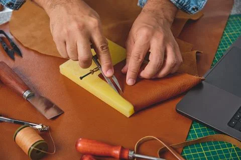 Shoemaker working leather with wing divider in workshop Stock Photos