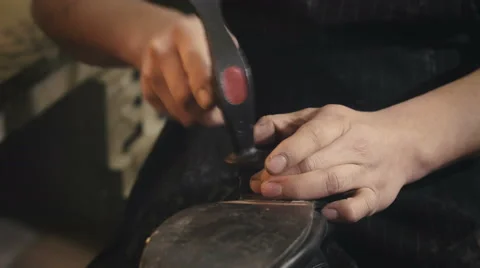 Shoemaker works with a hammer Stock Footage 61790520