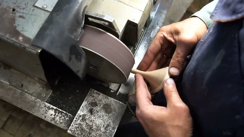 The shoemaker's sharpening metal taps on the machine Stock Footage 77917443