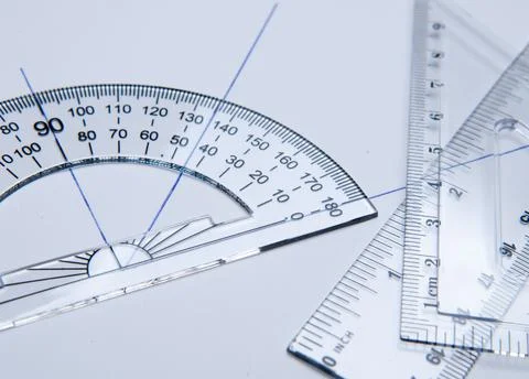 Shool materials for drawing: bevel, square and angle meter on a white paper Stock Photos